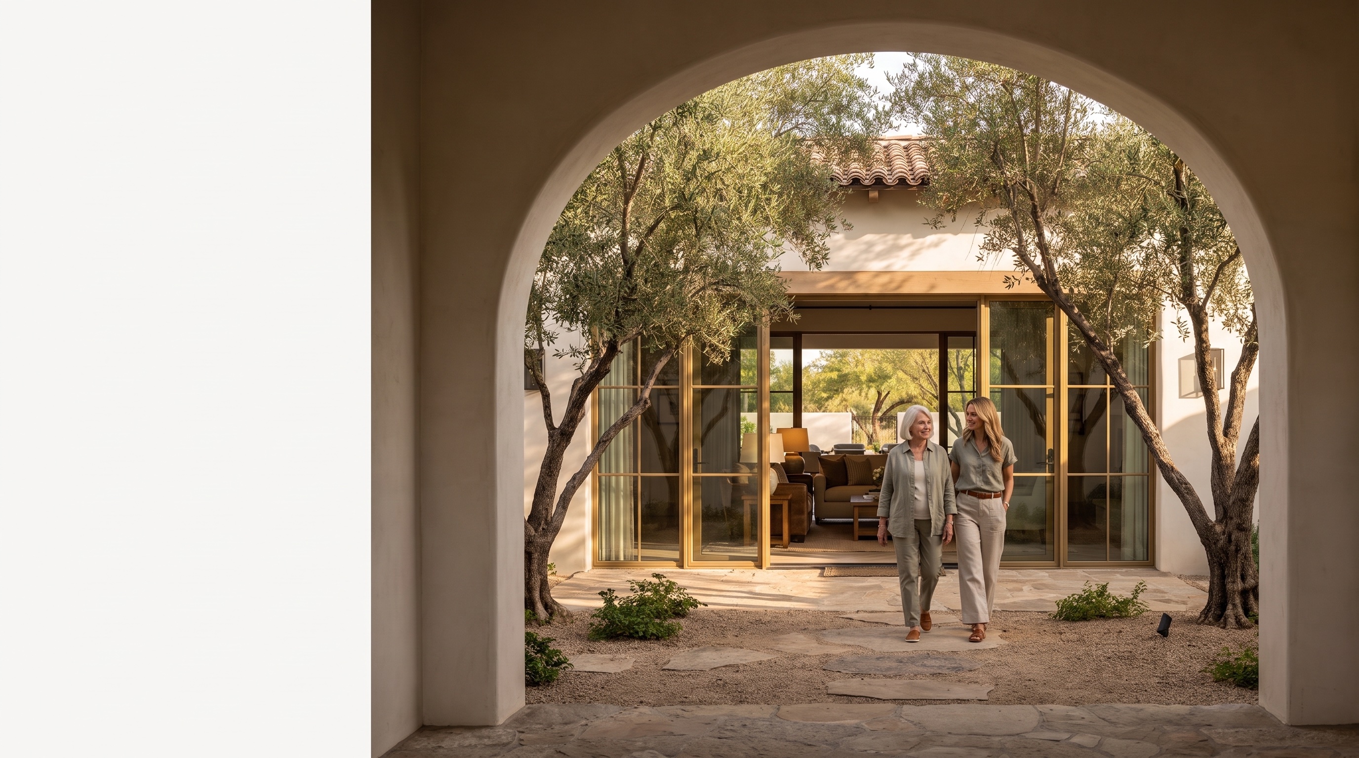 A mother and daughter approaching a warm residential home through a limestone arch at golden hour
